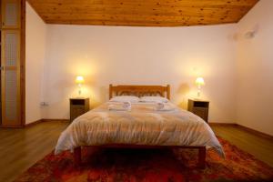 a bedroom with a bed with two lamps on two tables at The Old Olive Mill House by TrulyCyprus in Doros