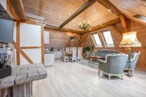 Il comprend un grand salon avec des plafonds en bois et une cuisine. dans l'établissement KUBU 4-rooms apartment, à Klaipėda