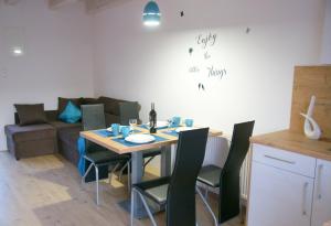 - une salle à manger avec une table, des chaises et un canapé dans l'établissement Koral Apartmenty, à Sarbinowo