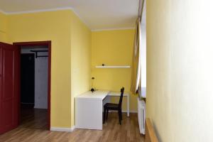 a yellow room with a desk and a chair at T apartment in Ulaanbaatar