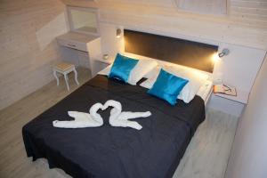 Deux cygnes faits pour ressembler à des cœurs sur un lit dans l'établissement Koral Apartmenty, à Sarbinowo