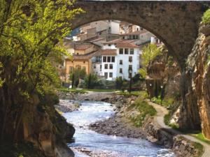 a bridge over a river with buildings in the background at Casita de Noah by Apartamentos Arnedillo in Arnedillo