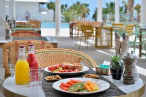 a table with two plates of fruit and juice at INNSiDE by Meliá Fuerteventura – Adults Only in Costa Calma