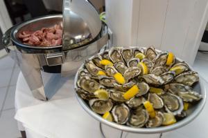 a bowl of clams and a plate of meat at Thalacap Île de Ré - Thalasso & Spa in Ars-en-Ré