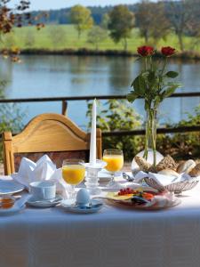 a table with food and drinks and a vase of flowers at Hotel Salinensee in Bad Dürrheim