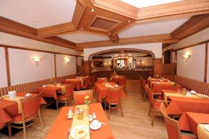 バート・デュルハイムにあるHotel Salinenseeのオレンジ色のテーブルと椅子が備わるレストラン