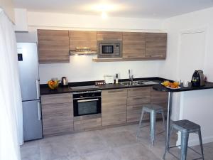 uma cozinha com armários de madeira e electrodomésticos de aço inoxidável em Le Sunlight, quiet and cosy with terrace! em Nice
