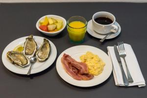 a table with two plates of breakfast food and a cup of coffee at Thalacap Île de Ré - Thalasso & Spa in Ars-en-Ré