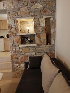 sala de estar con pared de piedra y sofá en Nafplio cozy mountain cottage en Nauplia