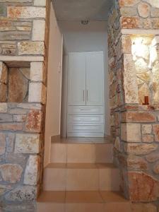 ナフプリオにあるNafplio cozy mountain cottageの白いドアと石壁の部屋
