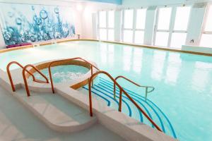 a swimming pool with a slide in the water at Thalacap Île de Ré - Thalasso & Spa in Ars-en-Ré