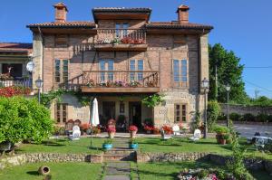 una gran casa de ladrillo con flores en el patio delantero en Posada La Cotía, en Helguera