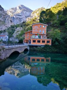 a building on a bridge over a body of water at Hostal Poncebos in Poncebos
