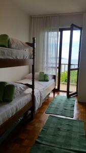 1 Schlafzimmer mit 2 Betten und einer Glasschiebetür in der Unterkunft Podaca house in Podaca