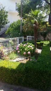 einen Garten mit rosa Blumen und einem weißen Zaun in der Unterkunft Podaca house in Podaca