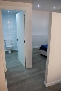 a bathroom with a toilet and a room with a door at Aparportu in Mundaka