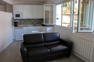 a living room with a leather couch in a kitchen at Aparportu in Mundaka