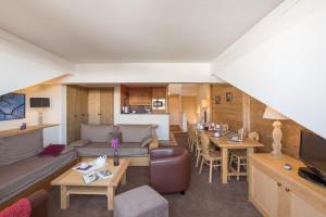 a living room with a couch and a table at Résidence Pierre & Vacances Premium Les Chalets du Forum in Courchevel