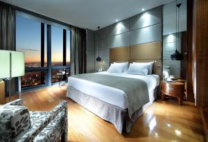 a bedroom with a large bed and a large window at Eurostars Madrid Tower in Madrid