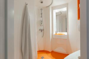 baño blanco con ducha y lavamanos en easyHotel Budapest Oktogon, en Budapest