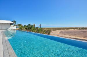 a swimming pool with the beach in the background at INNSiDE by Meliá Fuerteventura – Adults Only in Costa Calma