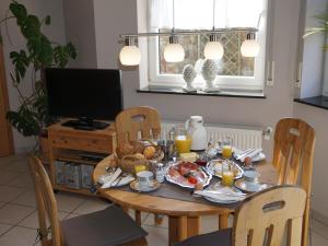 Sch ne Wohnung in der Moselregion في Kinheim: طاولة طعام مع طعام الإفطار وعصير البرتقال