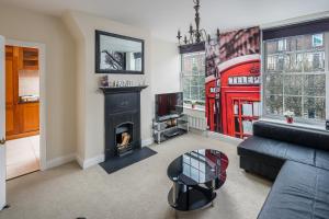 a living room with a fireplace and a red phone booth at Skyline Serviced Apartments - London Bridge in London
