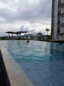 una persona en una piscina con un objeto de madera en el agua en Centrio Tower Beside Ayala Studio Unit 1 - 9 en Cagayán de Oro