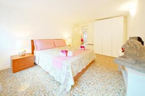 Un dormitorio con una cama con paquetes rosados. en Sant'Aponal Apartment Rialto, en Venecia