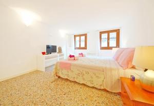 1 dormitorio blanco con 1 cama y TV en Sant'Aponal Apartment Rialto, en Venecia