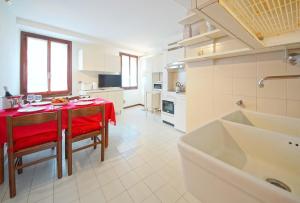 a kitchen with a table with a red table cloth at Calle dei Fabbri Apartment in Venice