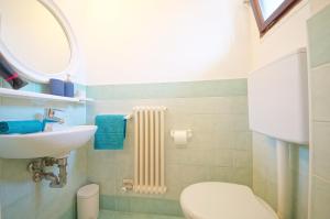 y baño con aseo blanco y lavamanos. en Calle dei Fabbri Apartment, en Venecia