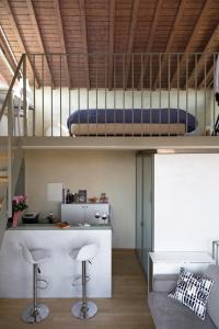 a loft bed in a room with a bar and a couch at The Artist's Loft in Lucca