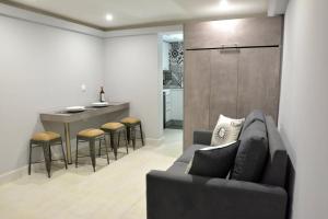 een woonkamer met een bank en een keuken bij Liston Apartment in Corfu-stad