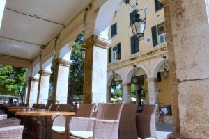 an outdoor patio with chairs and tables and a building at Liston Apartment in Corfu