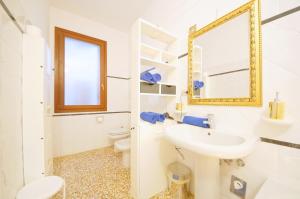 a white bathroom with a sink and a mirror at Santa Marina Apartment Rialto in Venice