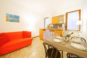 a living room with a orange couch and a table at Santa Marina Apartment Rialto in Venice