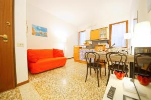 a living room with an orange couch and a table at Santa Marina Apartment Rialto in Venice
