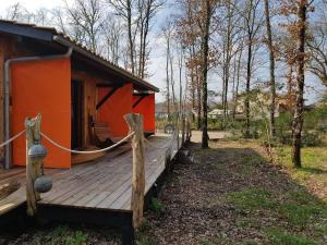 a cabin with a wooden deck in the woods at Au Bois Flotté in Hourtin