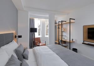 a bedroom with a large white bed and a chair at Coffee Fellows Hotel Dortmund in Dortmund +43 photos