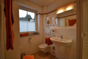 Un baño con lavabo, inodoro y ventana. en Ferienweingut Port, en Bernkastel-Kues 7 fotos más
