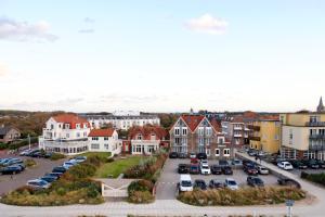 a town with cars parked in a parking lot at Hotel Noordzee in Domburg