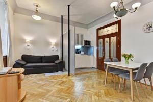 uma sala de estar com um sofá preto e uma mesa em Historic Centre Apartments VIII em Praga