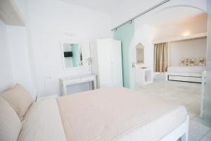 um quarto branco com uma cama num quarto em Aspasia Luxury Apartments em Agia Anna (Naxos)