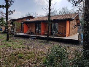 a cabin in the woods with a wrap around porch at Au Bois Flotté in Hourtin