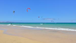 a group of people kite surfing in the ocean at INNSiDE by Meliá Fuerteventura – Adults Only in Costa Calma