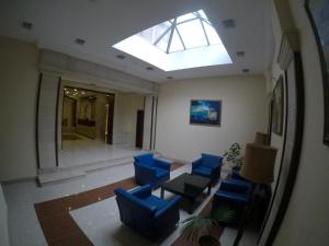 Habitación con sillas azules y tragaluz. en Premier Hotel, en Baku