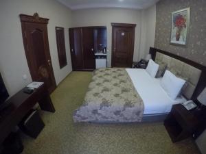 バクーにあるプレミア ホテルの大きなベッドとキッチンが備わるホテルルームです。