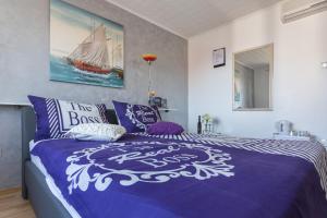 a bedroom with a bed with a blue and white comforter at Guesthouse Ivona in Dubrovnik