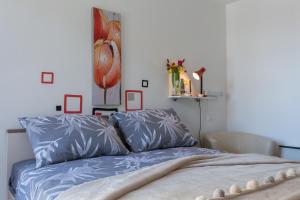a bedroom with a bed with blue sheets and a painting at Guesthouse Ivona in Dubrovnik